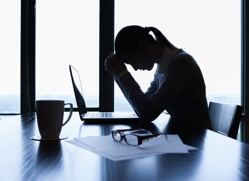 Mujer sufriendo en la oficina problemas psicosomaticos, sin saber que poder hacer